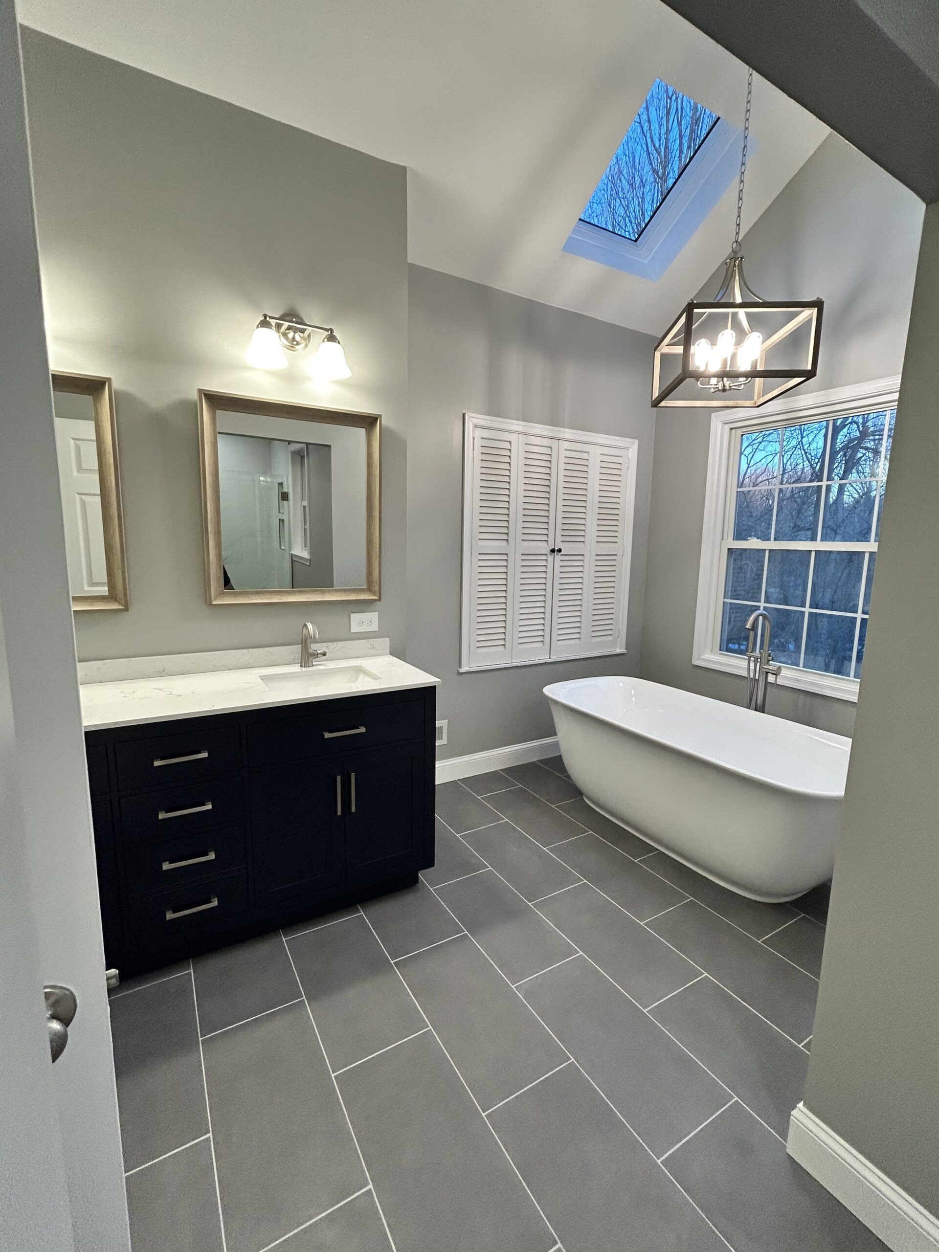 Master bathroom remodel with freestanding bathtub new chandelier and porcelain tile floor