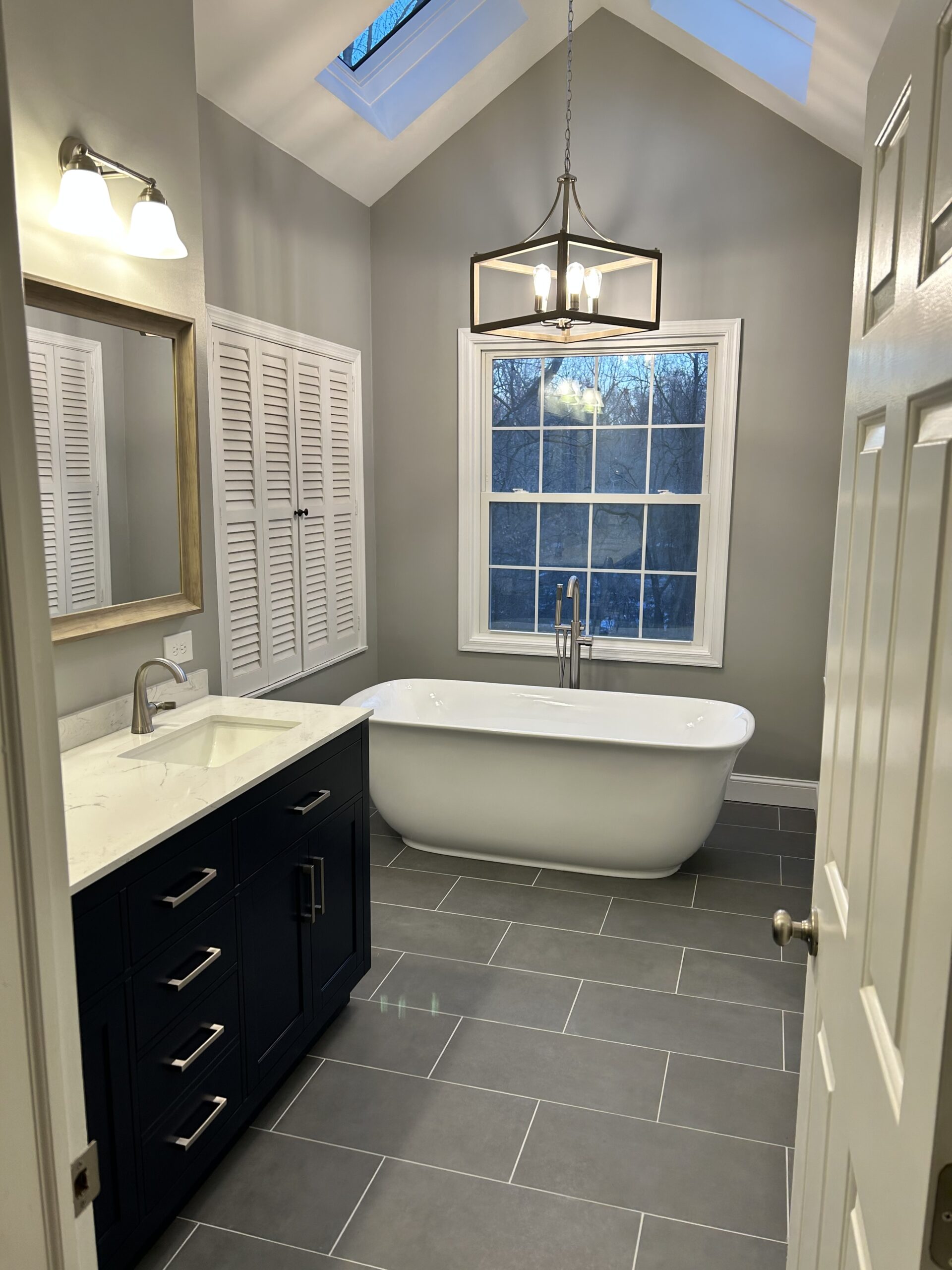 Master bathroom remodel with freestanding bathtub tile floor and double vanity with new fixtures